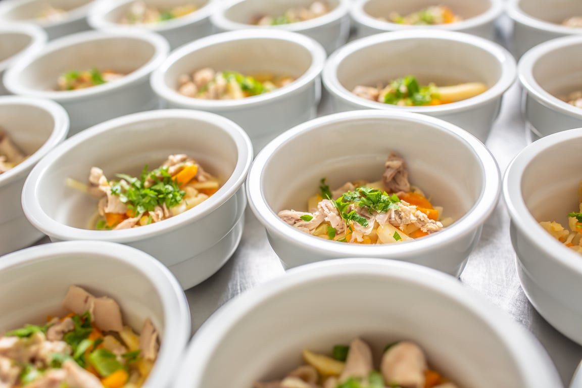 Bowls of chicken soup lined up for serving.